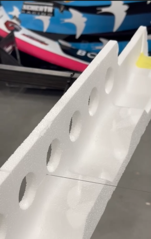 Zdjęcie przedstawia proces cięcia styropianu.